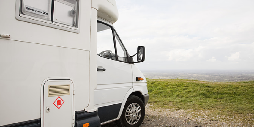 Side view of an RV parked and facing the horizon.